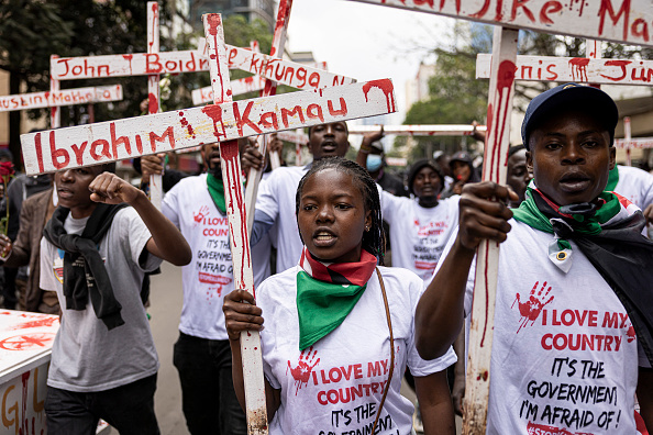 Protesters at a Kenya memorial march holding wooden crosses with victims' names